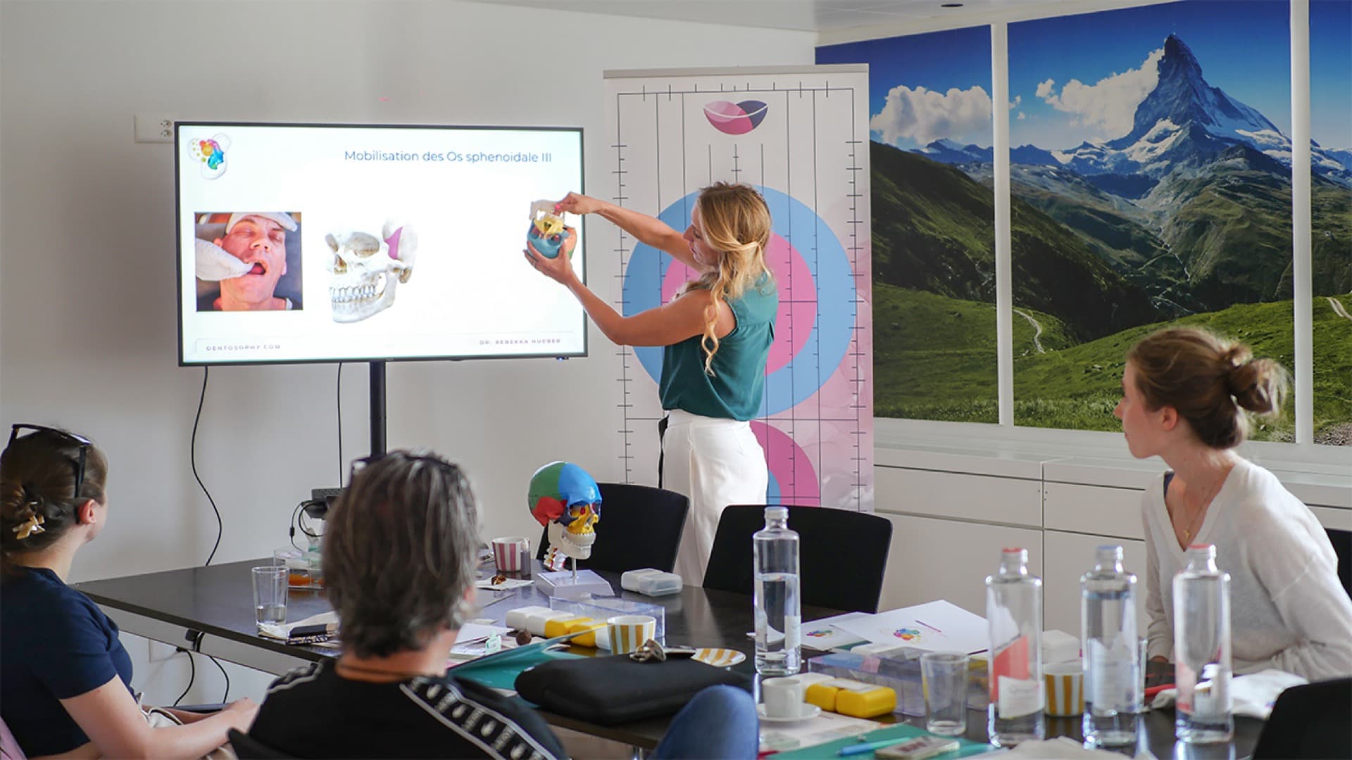 Workshop-Szene: Dr. med. dent. Rebekka Hueber erklärt Teilnehmenden das cranio-faziale System am Modell